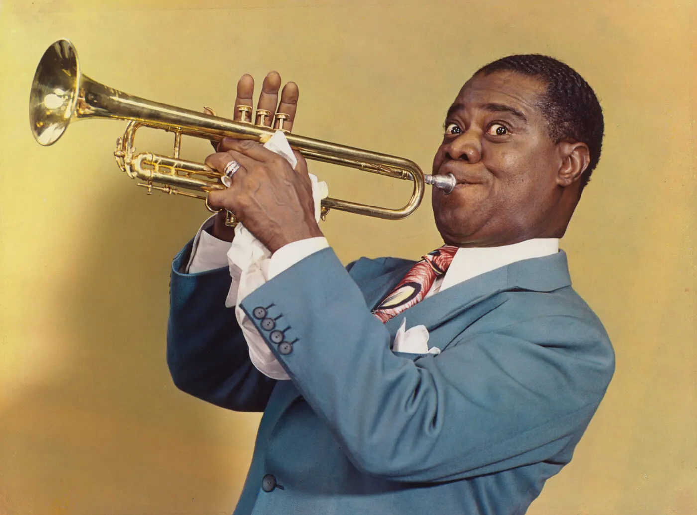 Louis Armstrong playing the trumpet in a color portrait