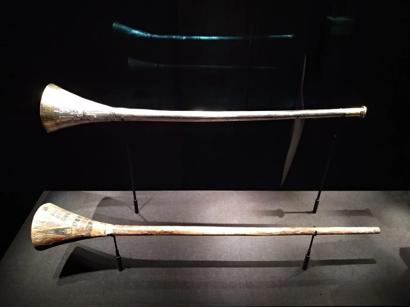 Tutankhamun's straight silver trumpet displayed beside its painted wooden insert